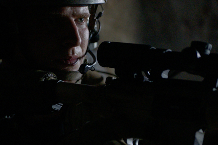 Stock image of SWAT team calling out to team while aiming his weapon